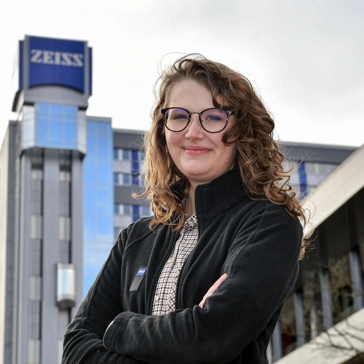 Ann-Marijke Mindrup steht mit verschränkten Armen vor dem ZEISS-Gebäude