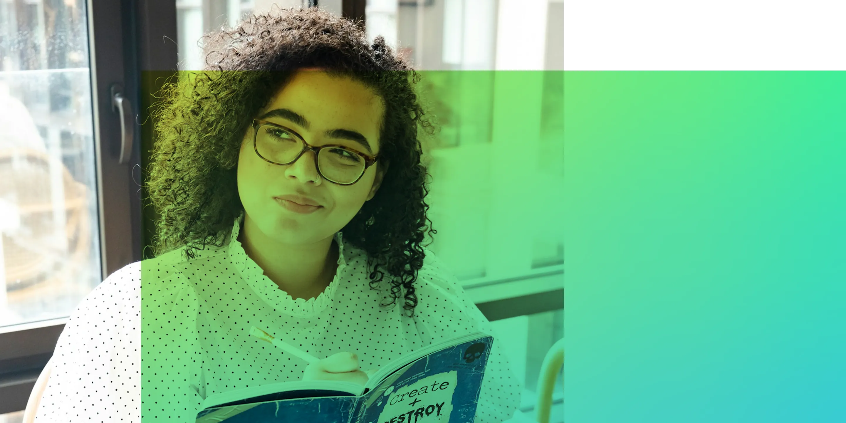Studentin mit Brille sitzt nachdenklich am Fenster und macht sich Notizen in ihr Notizbuch